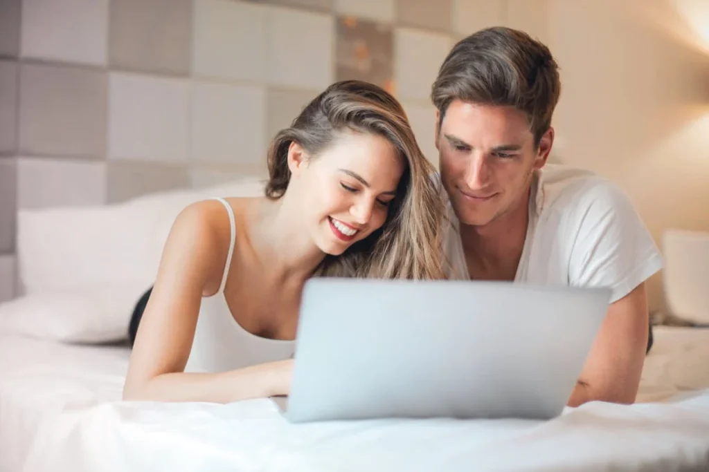 Couple reminiscing by looking at their old wedding photos, preserving wedding memories and celebrating their special day.